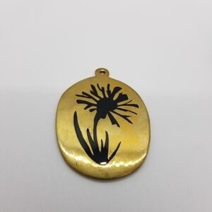 oval gold tone pendant with black flower